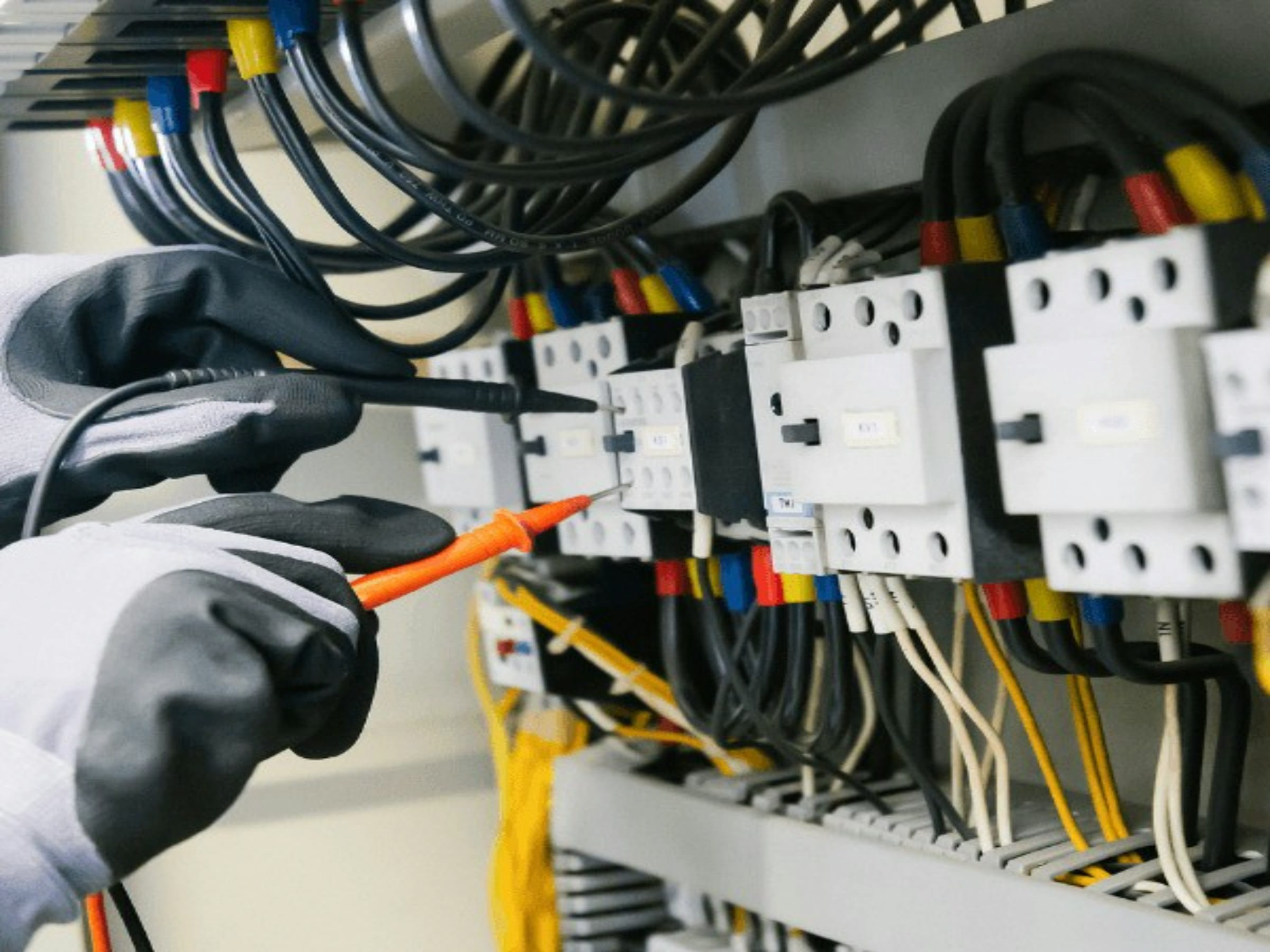 Technicien contrôlant les contacteurs d’une armoire électrique